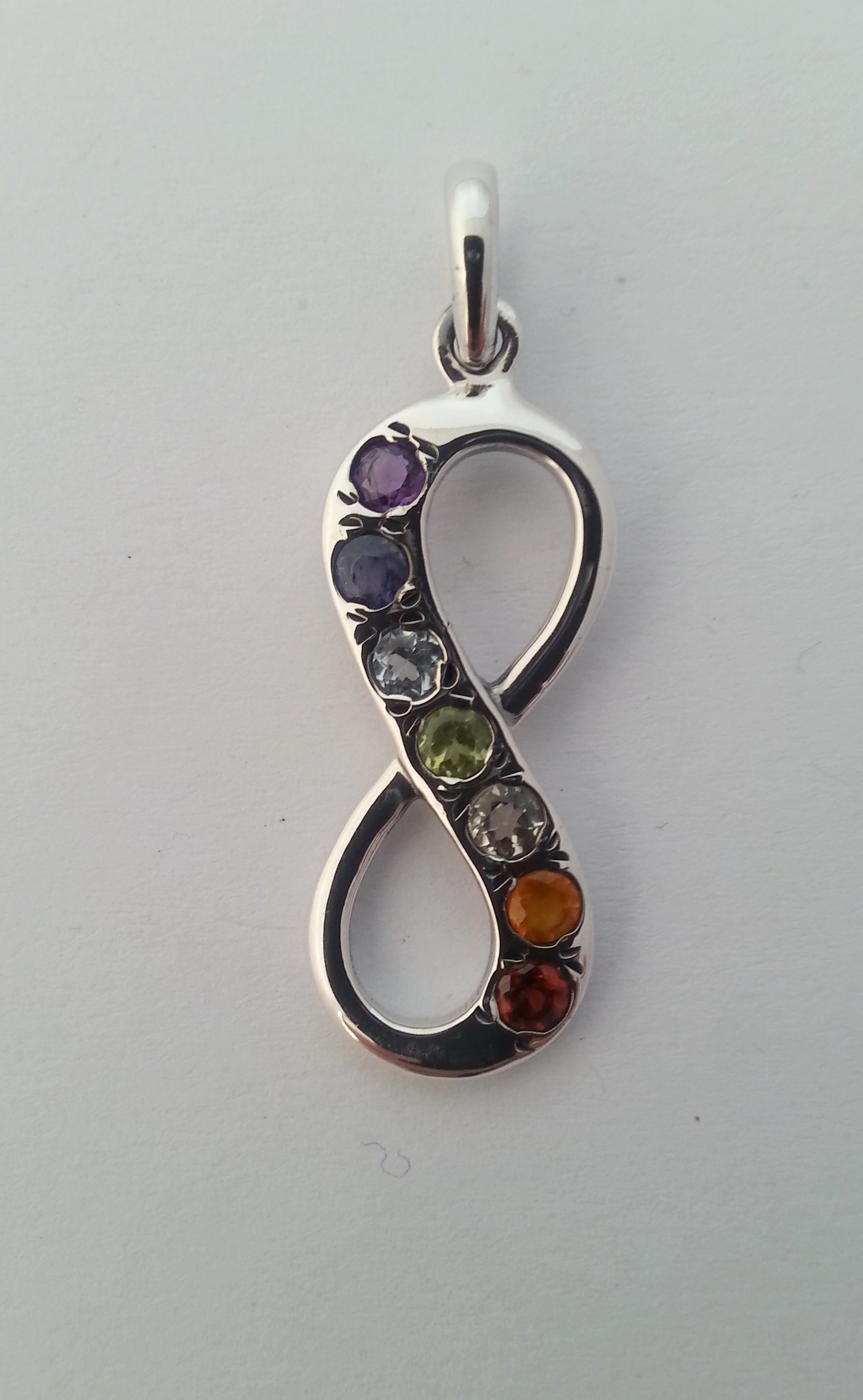 Infinity symbol or eternity knot with chakra gemstones