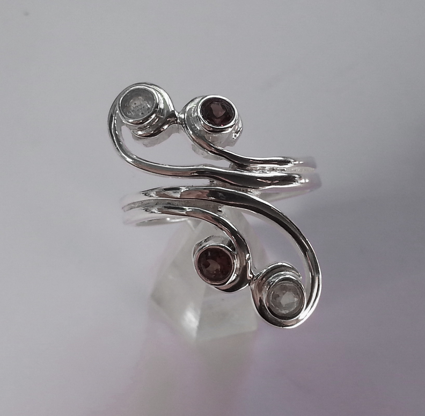 Spirals of sterling silver set with 4 faceted gemstones